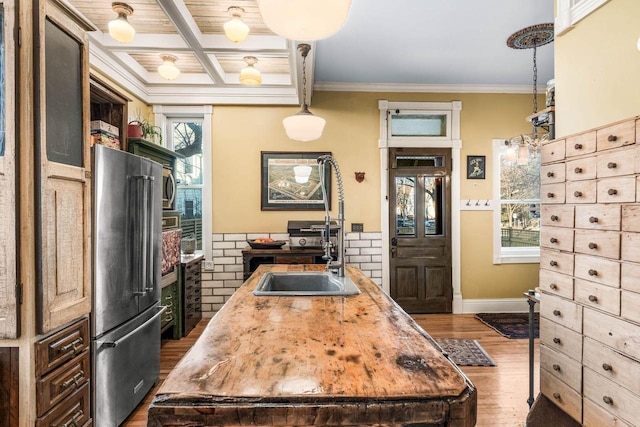 kitchen featuring coffered ceiling, dark wood-type flooring, a center island with sink, high end refrigerator, and beamed ceiling