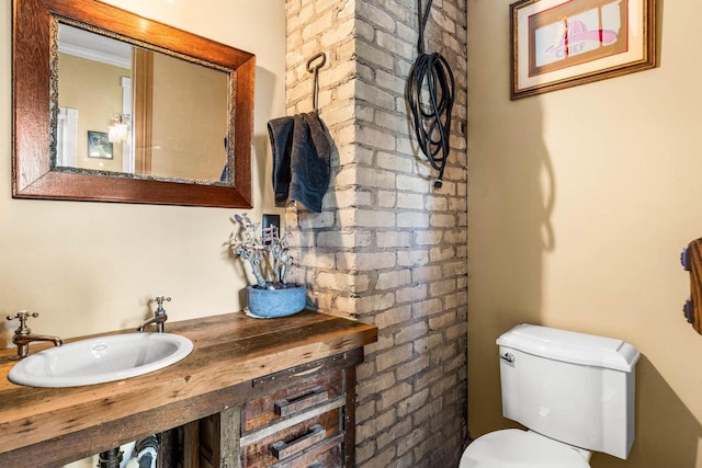 bathroom featuring sink, ornamental molding, and toilet