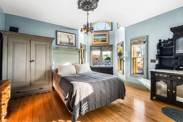 bedroom featuring an inviting chandelier and light wood-type flooring