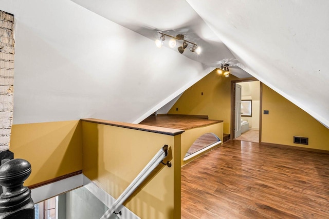 additional living space with ceiling fan, hardwood / wood-style floors, and vaulted ceiling