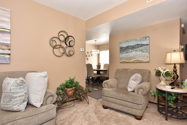 carpeted living room with an inviting chandelier