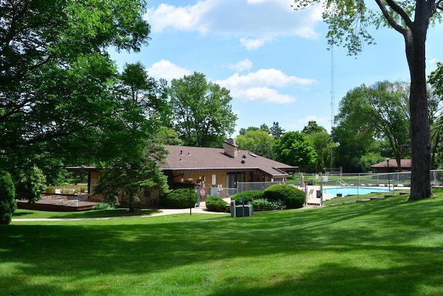 exterior space with a lawn and a swimming pool