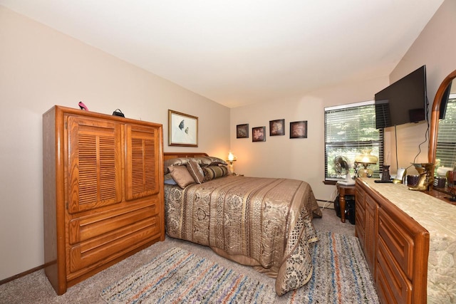 bedroom with baseboard heating and light carpet