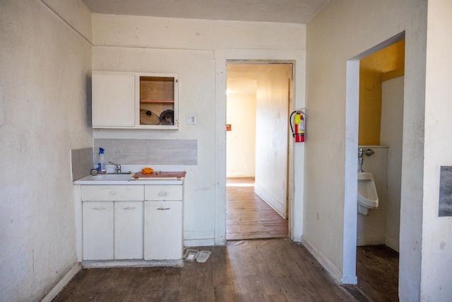 kitchen featuring dark hardwood / wood-style flooring, sink, and white cabinets