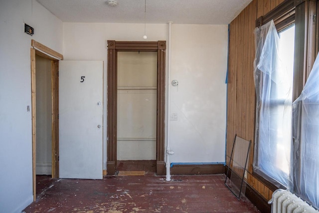 unfurnished bedroom featuring radiator heating unit