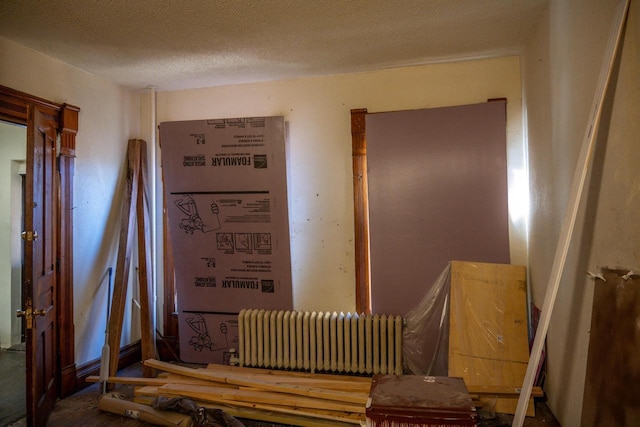 miscellaneous room featuring radiator heating unit and a textured ceiling