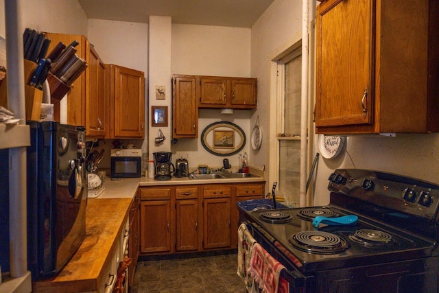 kitchen with black appliances, sink, and wooden counters