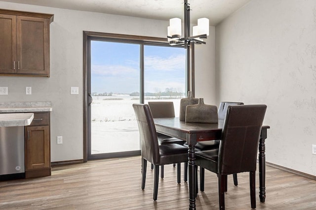 dining room with light hardwood / wood-style floors and a chandelier