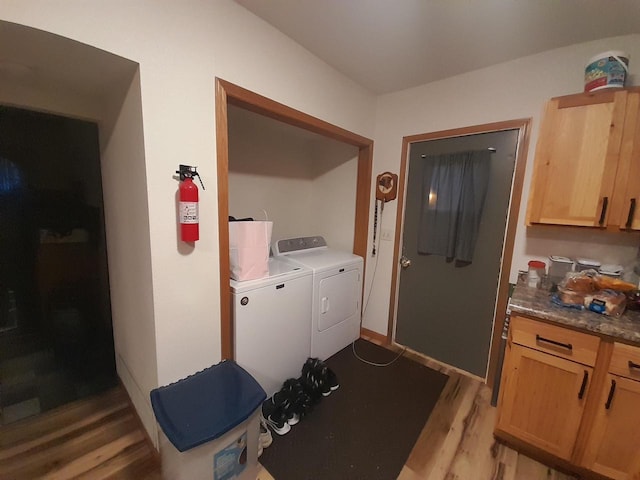 laundry area with laundry area, light wood-style flooring, baseboards, and washer and clothes dryer