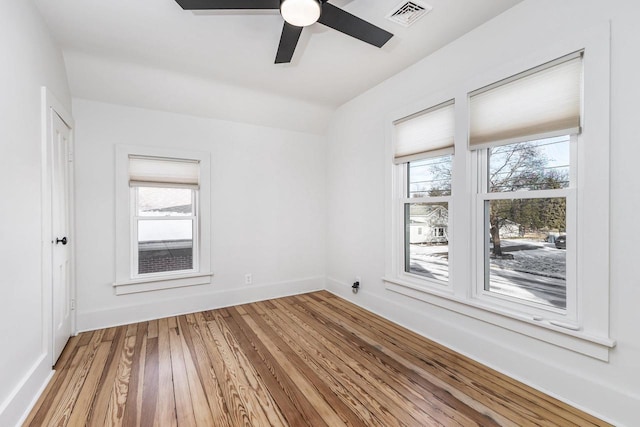 616 Elk St, Sabula, IA 52070 - empty room featuring ceiling fan, a wealth of natural light, and wood-type flooring