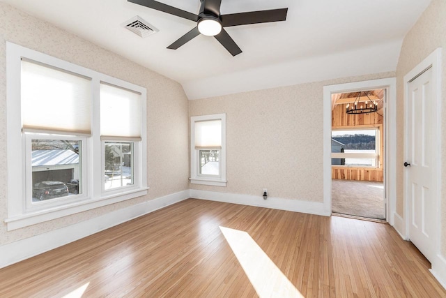 616 Elk St, Sabula, IA 52070 - spare room featuring ceiling fan with notable chandelier, light hardwood / wood-style floors, and lofted ceiling