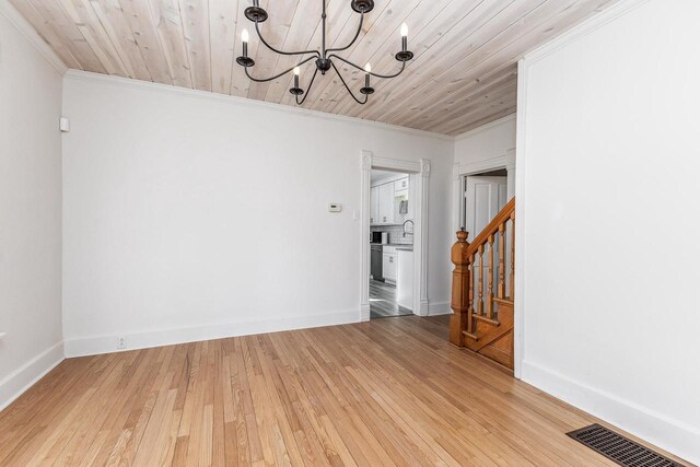 616 Elk St, Sabula, IA 52070 - spare room with light wood-type flooring, wooden ceiling, crown molding, and an inviting chandelier