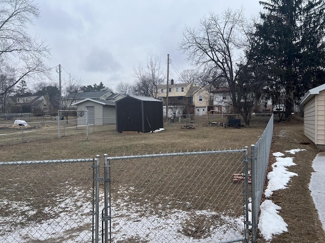 snowy yard featuring a storage unit