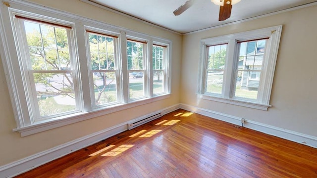 spare room featuring hardwood / wood-style floors, a baseboard radiator, ceiling fan, and crown molding