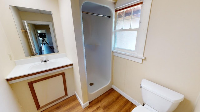 bathroom featuring walk in shower, toilet, vanity, and hardwood / wood-style flooring