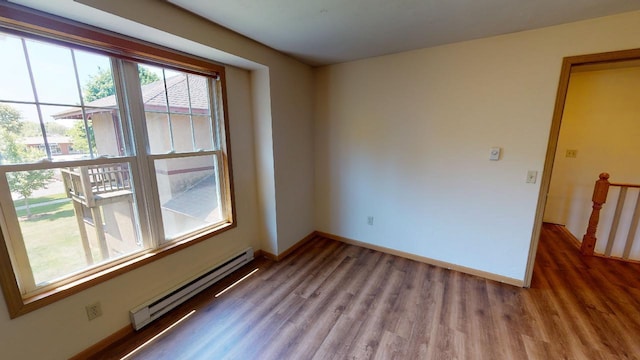 spare room featuring hardwood / wood-style flooring and a baseboard heating unit