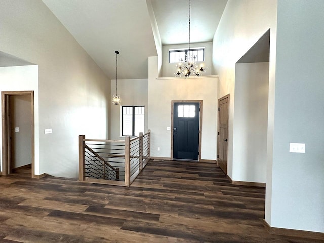 entrance foyer with a towering ceiling, dark hardwood / wood-style floors, and an inviting chandelier