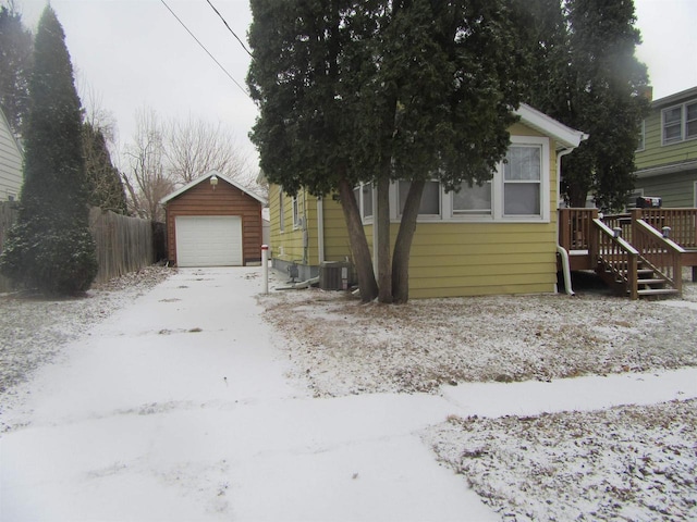 view of front facade with central air condition unit, an outbuilding, and a garage