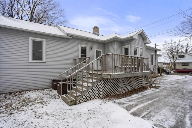 snow covered house featuring a deck