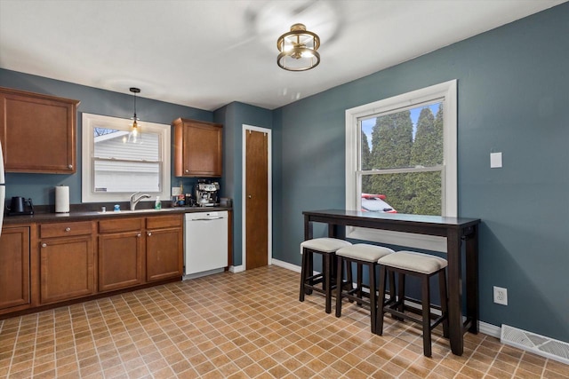 kitchen featuring dishwasher, decorative light fixtures, and sink