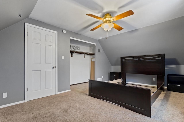 carpeted bedroom with ceiling fan, lofted ceiling, and a closet