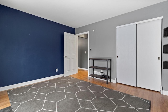 unfurnished bedroom featuring a closet and dark wood-type flooring