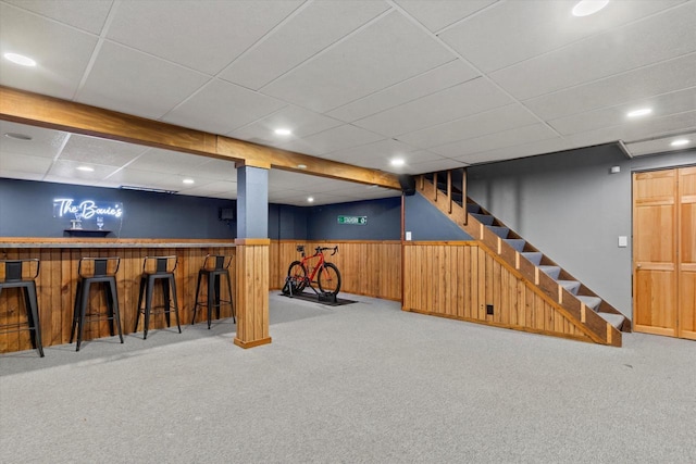 basement with light colored carpet and wooden walls