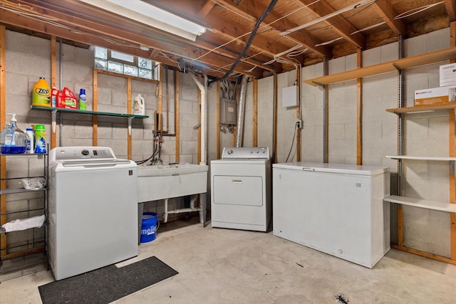 basement with electric panel, refrigerator, and washer and dryer