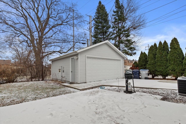 snow covered garage featuring central air condition unit