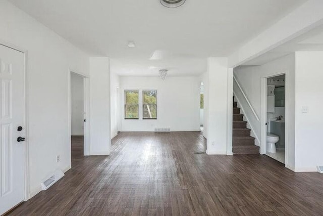 unfurnished living room with dark wood-type flooring