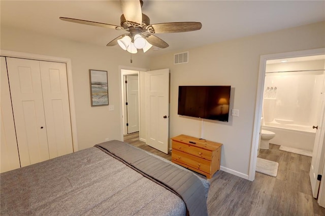 bedroom with a closet, ceiling fan, hardwood / wood-style flooring, and ensuite bathroom