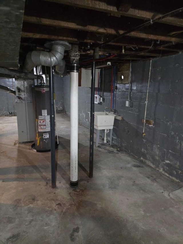 basement featuring gas water heater, heating unit, and sink