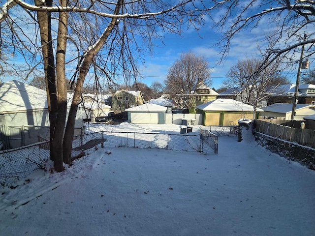 yard layered in snow with a garage and an outdoor structure