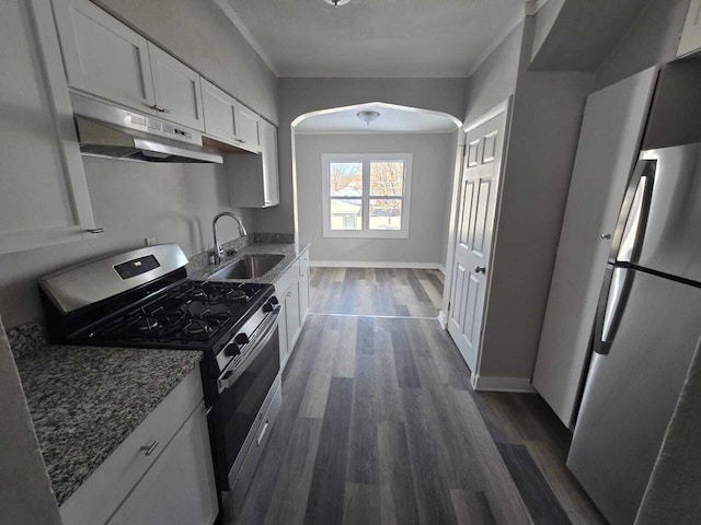 kitchen featuring sink, dark hardwood / wood-style floors, dark stone countertops, white cabinets, and appliances with stainless steel finishes