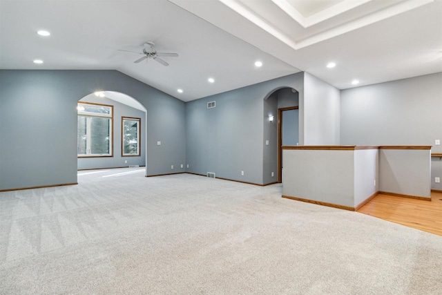 carpeted spare room featuring ceiling fan and lofted ceiling