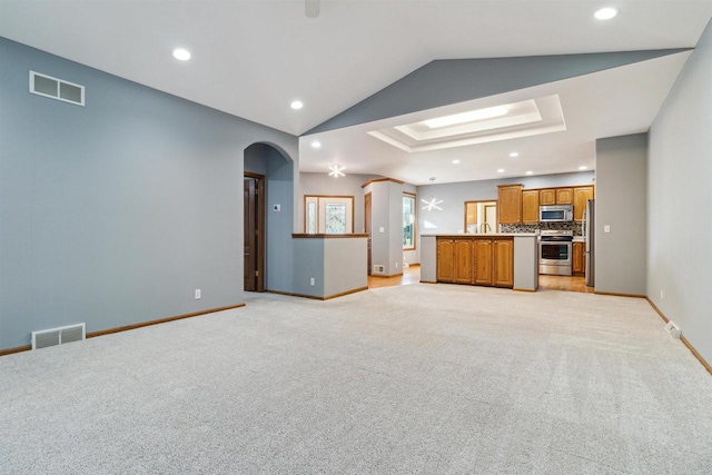 unfurnished living room featuring light colored carpet and lofted ceiling