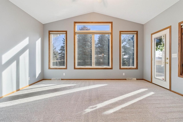 spare room featuring carpet and vaulted ceiling