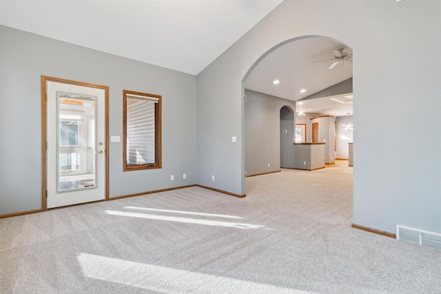 unfurnished room featuring ceiling fan, light colored carpet, and vaulted ceiling