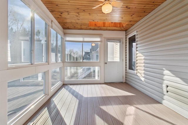 unfurnished sunroom with ceiling fan, plenty of natural light, and wood ceiling