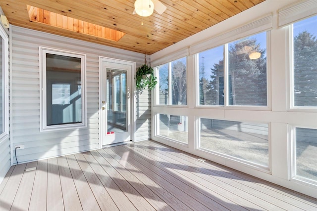 unfurnished sunroom with a skylight, ceiling fan, and wooden ceiling