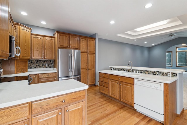 kitchen with sink, kitchen peninsula, stainless steel appliances, and tasteful backsplash