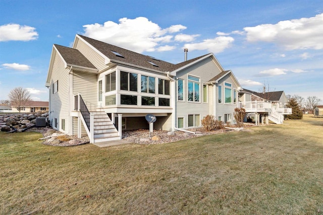 rear view of house with a yard, central AC, and a wooden deck