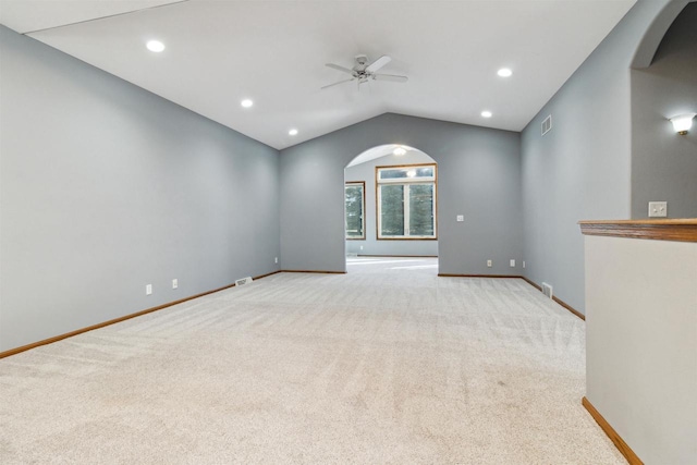 unfurnished room featuring ceiling fan, light colored carpet, and vaulted ceiling