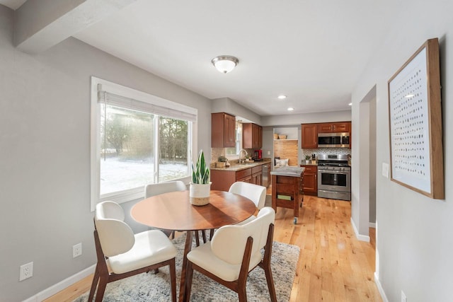 dining room with sink and light hardwood / wood-style flooring