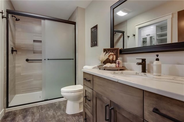 full bath featuring vanity, toilet, wood finished floors, and a stall shower