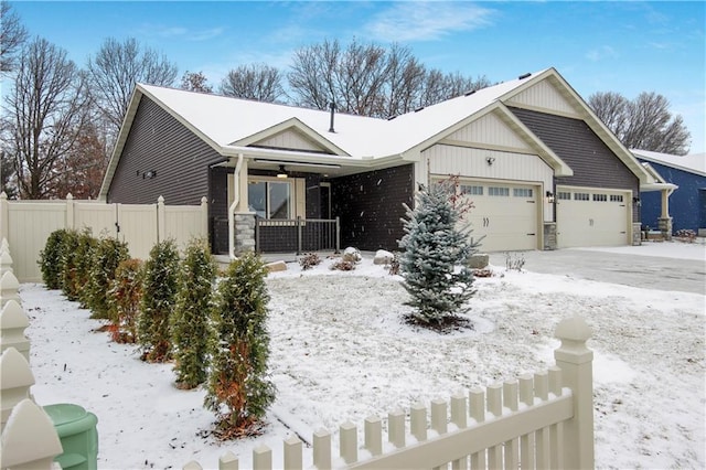 view of front of property with a porch, an attached garage, fence, and stone siding