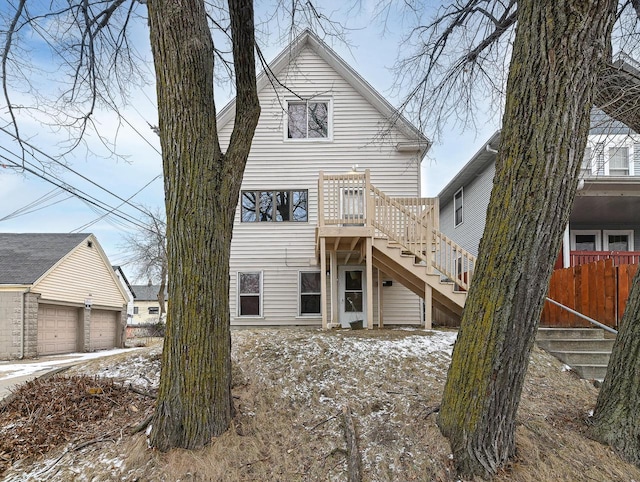 snow covered property featuring a garage and an outbuilding