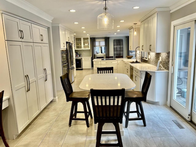 tiled dining space with ornamental molding and sink