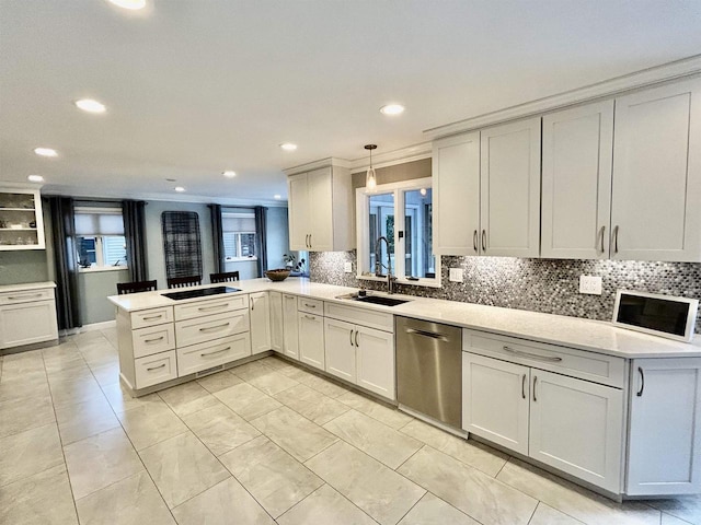 kitchen featuring sink, dishwasher, ornamental molding, kitchen peninsula, and pendant lighting