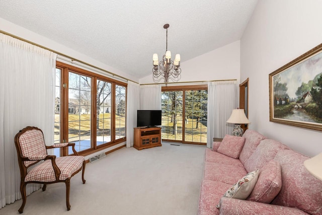 living room featuring carpet flooring, a textured ceiling, vaulted ceiling, and a notable chandelier